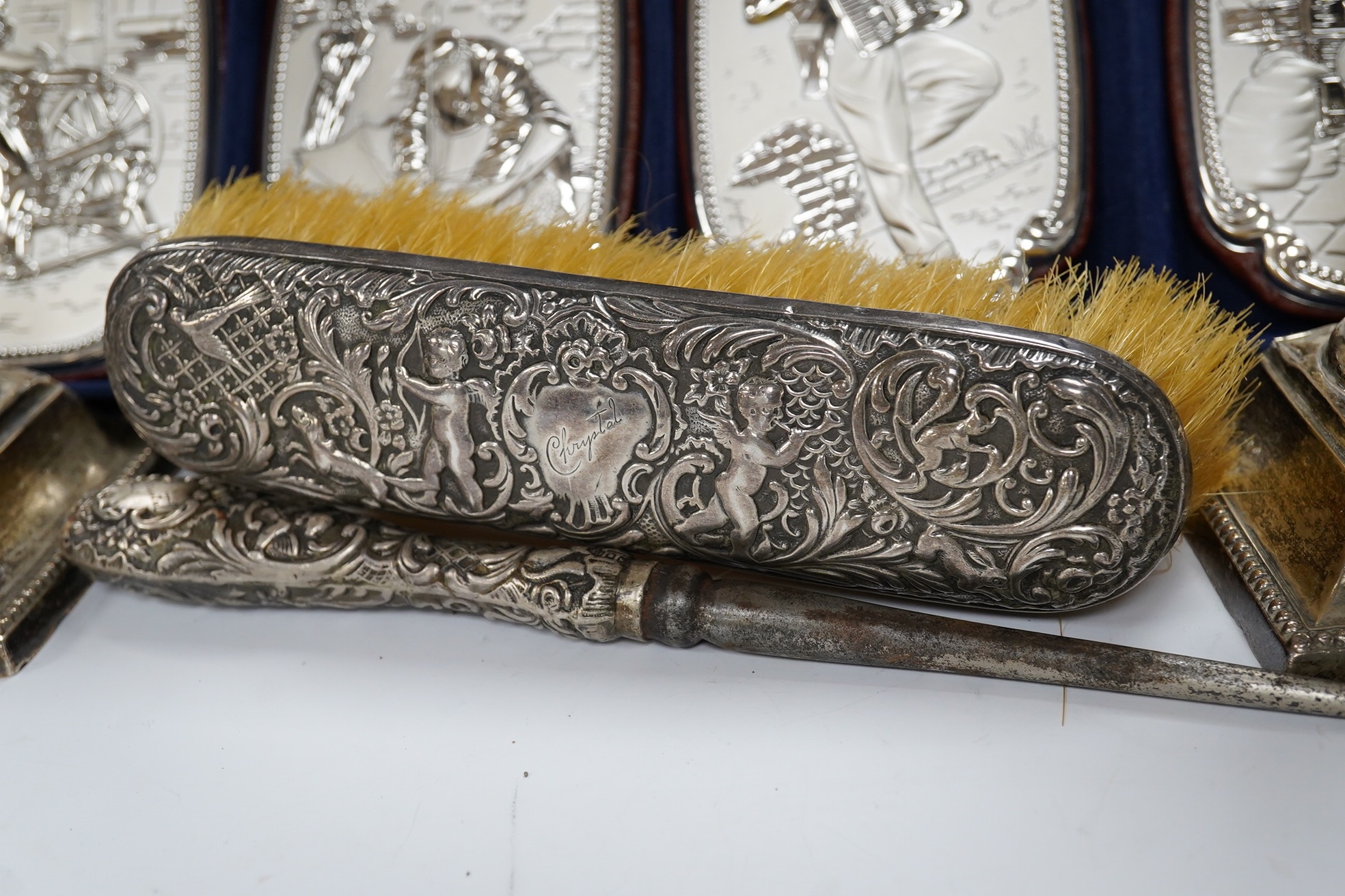 A pair of late Victorian silver dwarf candlesticks, by William Hutton & Sons, London, 1898, 13cm, weighted, together with a silver mounted button hook and clothes brush and a cased set of four 850 white metal mounted wal
